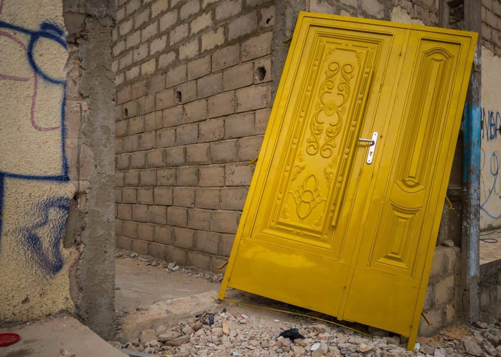 Brand new yellow door in the doorway of a concrete block house