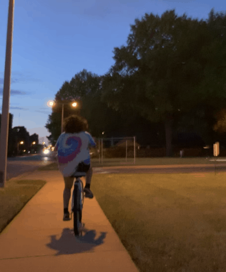 A person rides their bike at night.